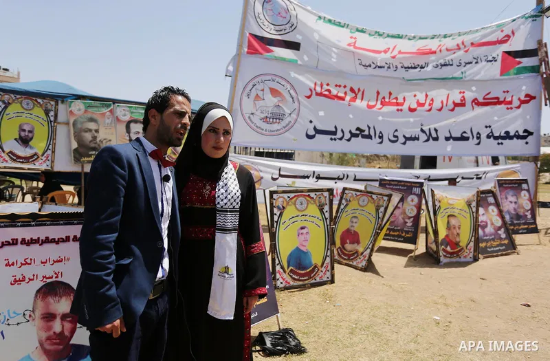A Palestinian groom and his bride take part in their marriage ceremony at a sit-in in support of Palestinian hunger-striking prisoners held in Israeli jails, on May 8, 2017, in Gaza City. Photo by Ashraf Amra
