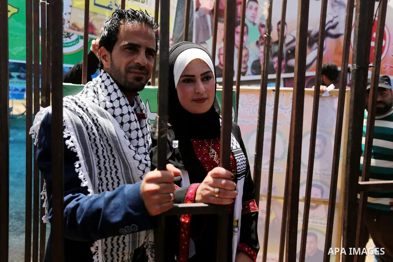 A Palestinian groom and his bride take part in their marriage ceremony at a sit-in in support of Palestinian hunger-striking prisoners held in Israeli jails, on May 8, 2017, in Gaza City. Photo by Ashraf Amra