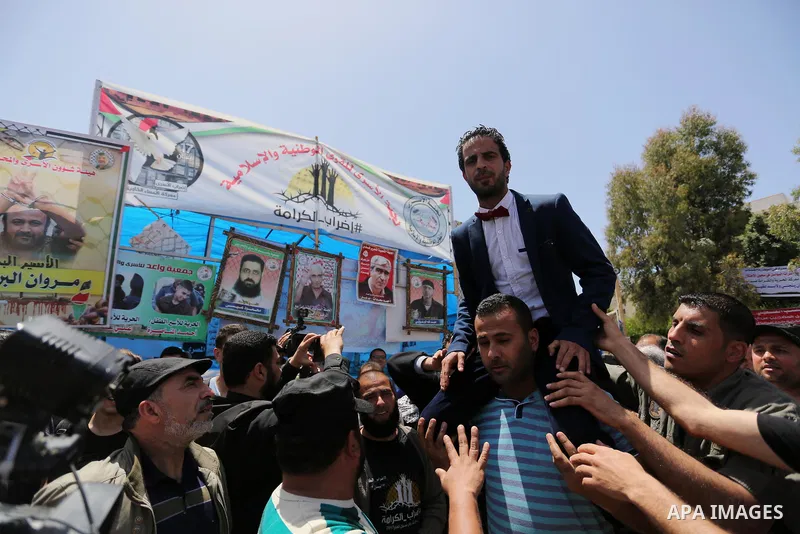 A Palestinian groom and his bride take part in their marriage ceremony at a sit-in in support of Palestinian hunger-striking prisoners held in Israeli jails, on May 8, 2017, in Gaza City. Photo by Ashraf Amra