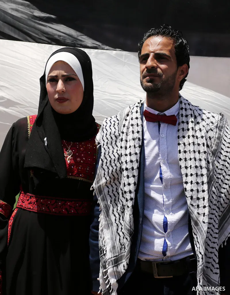 A Palestinian groom and his bride take part in their marriage ceremony at a sit-in in support of Palestinian hunger-striking prisoners held in Israeli jails, on May 8, 2017, in Gaza City. Photo by Ashraf Amra