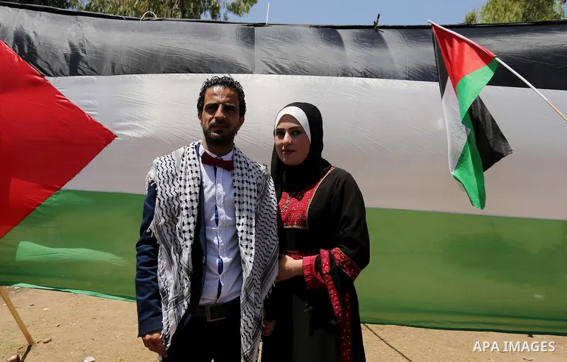 A Palestinian groom and his bride take part in their marriage ceremony at a sit-in in support of Palestinian hunger-striking prisoners held in Israeli jails, on May 8, 2017, in Gaza City. Photo by Ashraf Amra