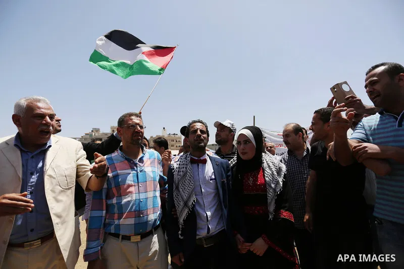 A Palestinian groom and his bride take part in their marriage ceremony at a sit-in in support of Palestinian hunger-striking prisoners held in Israeli jails, on May 8, 2017, in Gaza City. Photo by Ashraf Amra