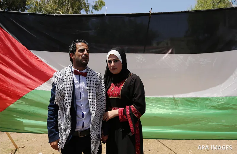 A Palestinian groom and his bride take part in their marriage ceremony at a sit-in in support of Palestinian hunger-striking prisoners held in Israeli jails, on May 8, 2017, in Gaza City. Photo by Ashraf Amra