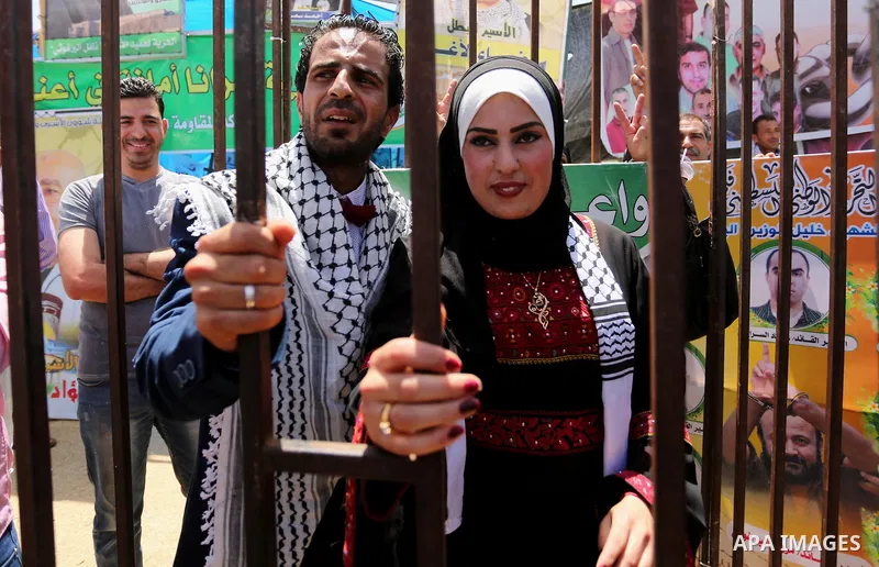 A Palestinian groom and his bride take part in their marriage ceremony at a sit-in in support of Palestinian hunger-striking prisoners held in Israeli jails, on May 8, 2017, in Gaza City. Photo by Ashraf Amra