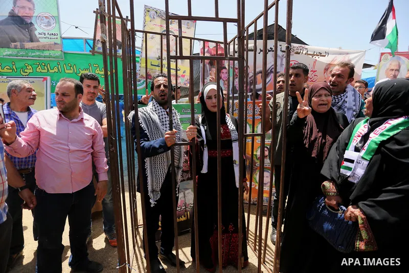 A Palestinian groom and his bride take part in their marriage ceremony at a sit-in in support of Palestinian hunger-striking prisoners held in Israeli jails, on May 8, 2017, in Gaza City. Photo by Ashraf Amra