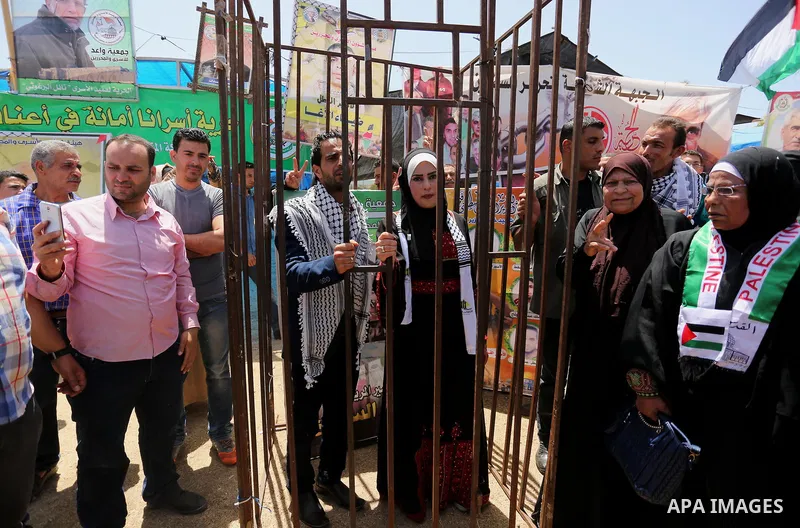 A Palestinian groom and his bride take part in their marriage ceremony at a sit-in in support of Palestinian hunger-striking prisoners held in Israeli jails, on May 8, 2017, in Gaza City. Photo by Ashraf Amra