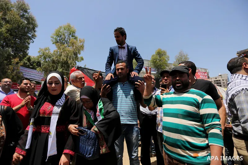 A Palestinian groom and his bride take part in their marriage ceremony at a sit-in in support of Palestinian hunger-striking prisoners held in Israeli jails, on May 8, 2017, in Gaza City. Photo by Ashraf Amra