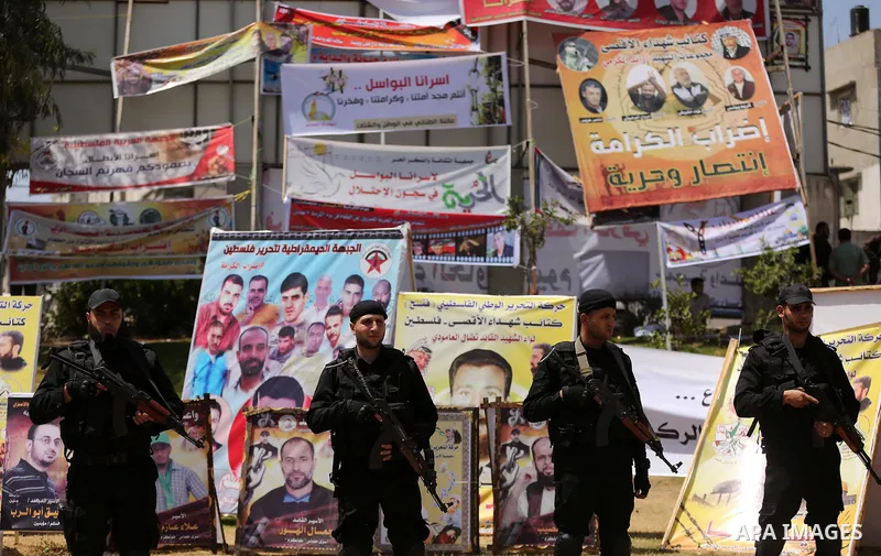 Palestinian ecurity forces stand guard during a visit of newly elected Hamas chief, Ismail Haniya, to protesters taking part in a sit-in in support of Palestinian hunger-striking prisoners held in Israeli jails, on May 8...