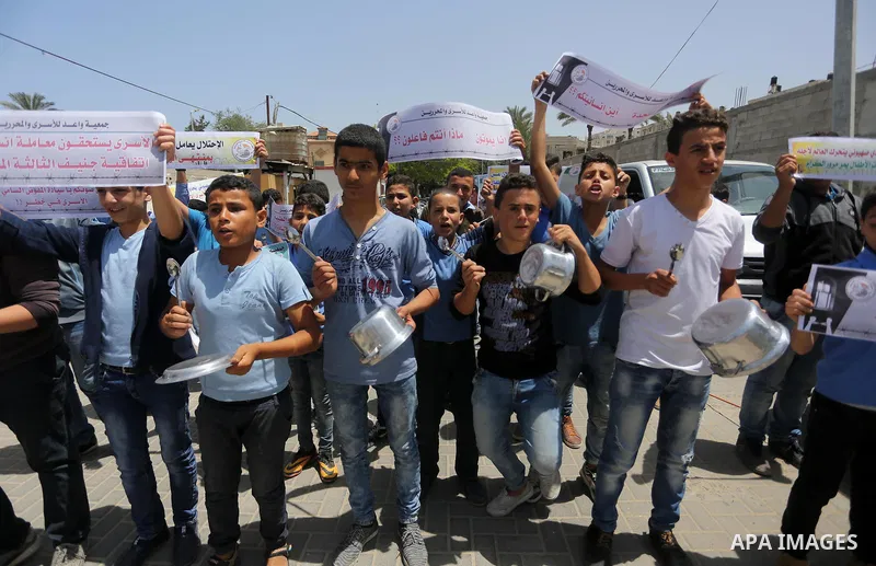 Palestinian children hold banners during a sit-in in support of Palestinian hunger-striking prisoners held in Israeli jails in front of the headquarter United Nation "UNSCO", on May 9, 2017, in Gaza City. Photo by Mohamm...