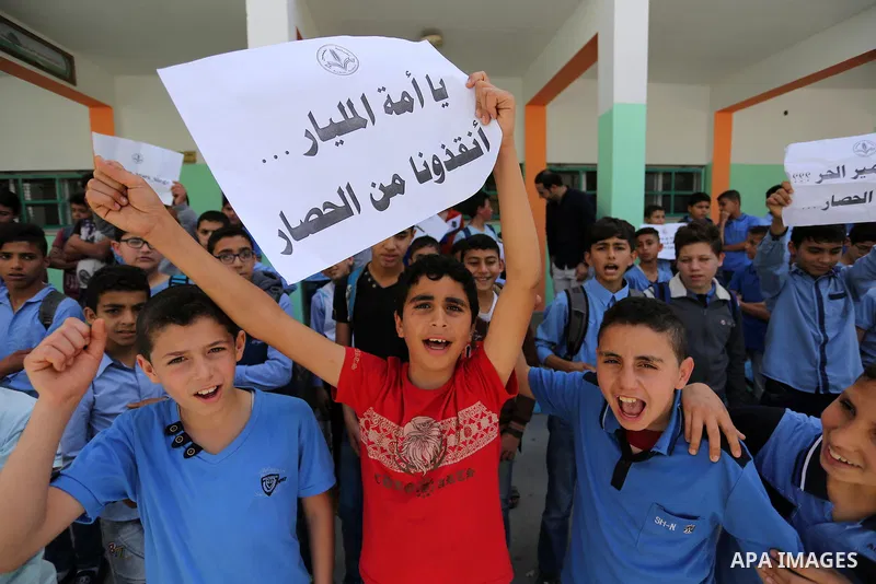 Palestinian students hold banners during a protest against Israeli blockade of the Gaza Strip, in Gaza city, on May 10, 2017. Photo by Ashraf Amra