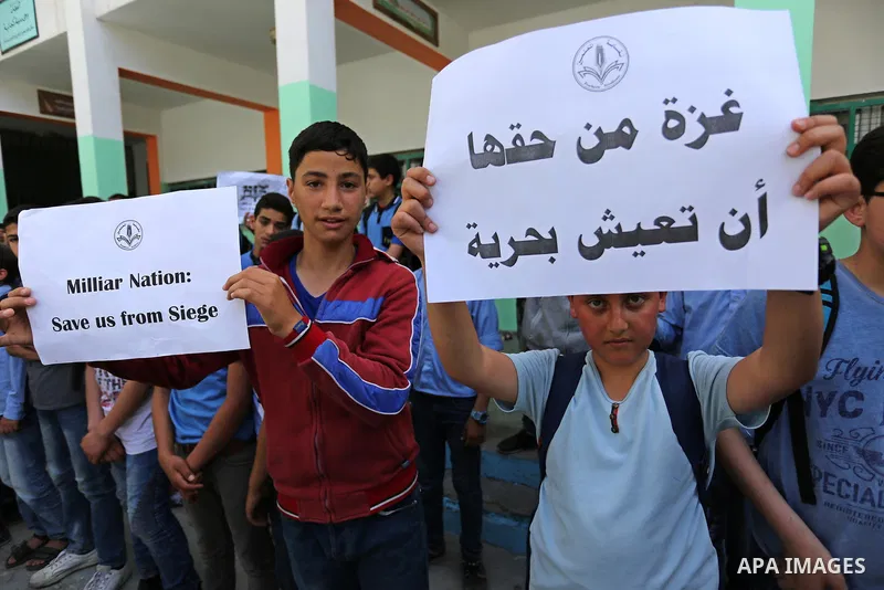Palestinian students hold banners during a protest against Israeli blockade of the Gaza Strip, in Gaza city, on May 10, 2017. Photo by Ashraf Amra