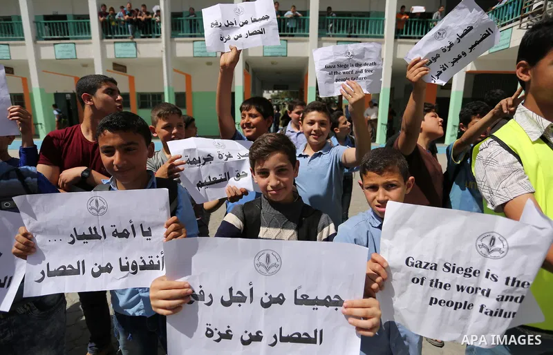 Palestinian students hold banners during a protest against Israeli blockade of the Gaza Strip, in Gaza city, on May 10, 2017. Photo by Ashraf Amra