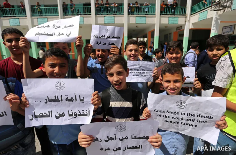Palestinian students hold banners during a protest against Israeli blockade of the Gaza Strip, in Gaza city, on May 10, 2017. Photo by Ashraf Amra