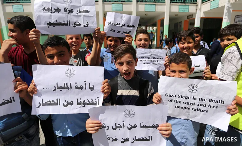 Palestinian students hold banners during a protest against Israeli blockade of the Gaza Strip, in Gaza city, on May 10, 2017. Photo by Ashraf Amra