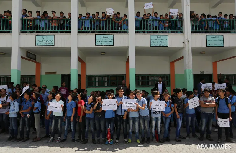Palestinian students hold banners during a protest against Israeli blockade of the Gaza Strip, in Gaza city, on May 10, 2017. Photo by Ashraf Amra
