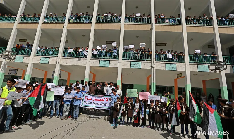 Palestinian students hold banners during a protest against Israeli blockade of the Gaza Strip, in Gaza city, on May 10, 2017. Photo by Ashraf Amra