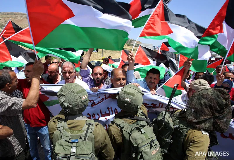 Palestinian protesters argue with Israeli soldiers during a demonstration in solidarity with Palestinian hunger-striking prisoners held in Israeli jails, at Israeli checkpoint of Hawara, near the West Bank city of Nablus...