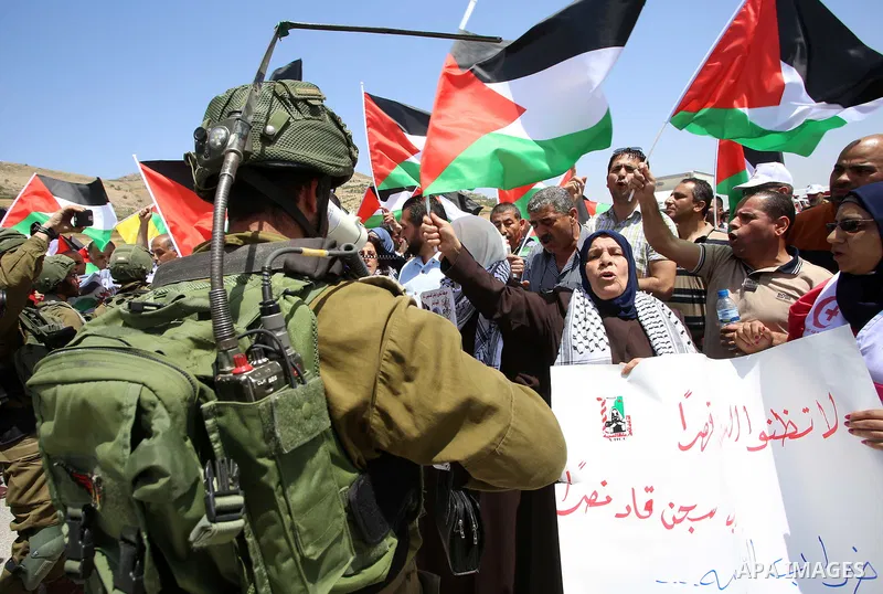 Palestinian protesters argue with Israeli soldiers during a demonstration in solidarity with Palestinian hunger-striking prisoners held in Israeli jails, at Israeli checkpoint of Hawara, near the West Bank city of Nablus...