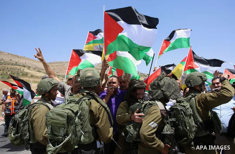 Palestinian protesters argue with Israeli soldiers during a demonstration in solidarity with Palestinian hunger-striking prisoners held in Israeli jails, at Israeli checkpoint of Hawara, near the West Bank city of Nablus...