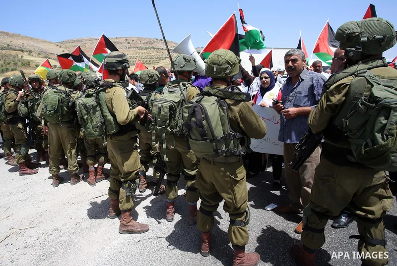 Palestinian protesters argue with Israeli soldiers during a demonstration in solidarity with Palestinian hunger-striking prisoners held in Israeli jails, at Israeli checkpoint of Hawara, near the West Bank city of Nablus...