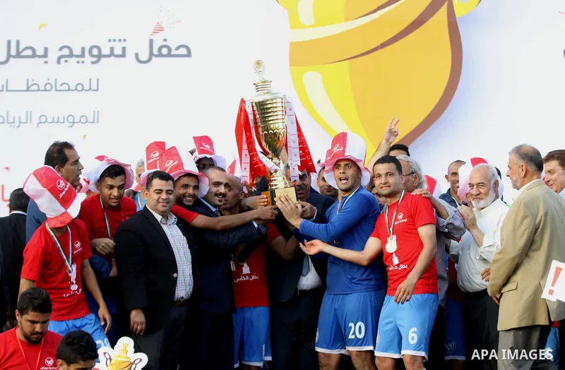 Palestinian Shabab Rafah football club players celebrate with the trophy after beating Khadamat Rafah football club during the final match of the Gaza Cup at Yarmouk stadium in Gaza City, on May 12, 2017. Photo by Ali Ha...
