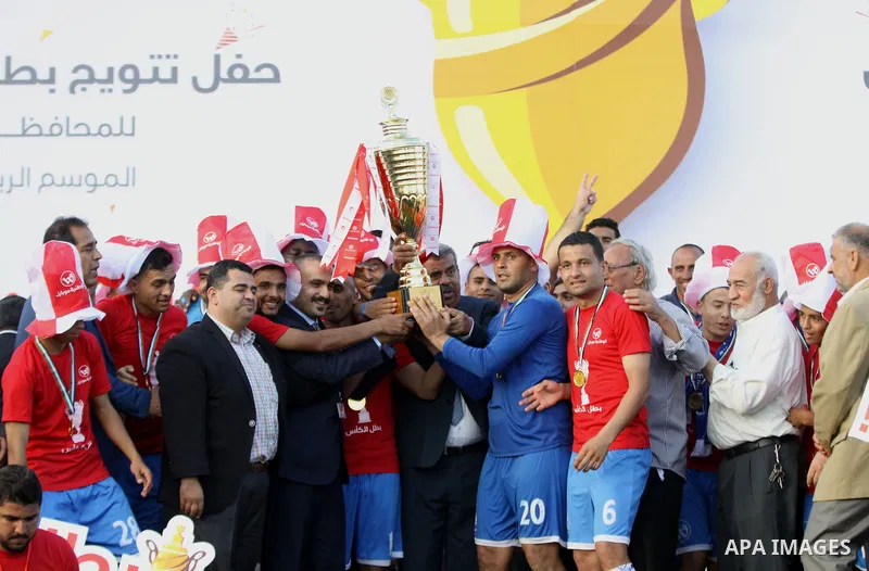 Palestinian Shabab Rafah football club players celebrate with the trophy after beating Khadamat Rafah football club during the final match of the Gaza Cup at Yarmouk stadium in Gaza City, on May 12, 2017. Photo by Ali Ha...
