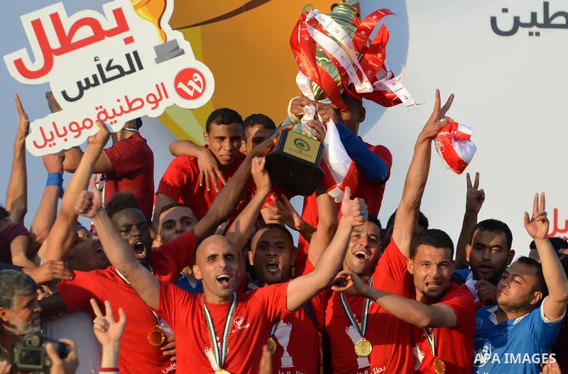 Palestinian Shabab Rafah football club players celebrate with the trophy after beating Khadamat Rafah football club during the final match of the Gaza Cup at Yarmouk stadium in Gaza City, on May 12, 2017. Photo by Mohamm...