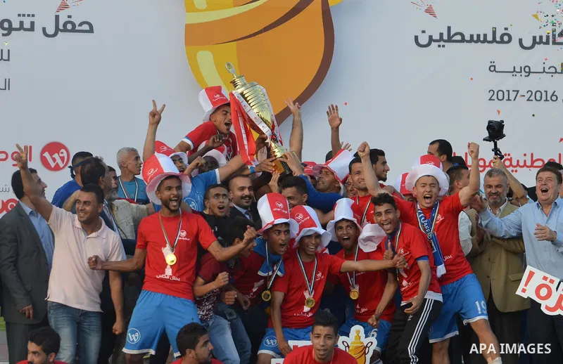 Palestinian Shabab Rafah football club players celebrate with the trophy after beating Khadamat Rafah football club during the final match of the Gaza Cup at Yarmouk stadium in Gaza City, on May 12, 2017. Photo by Mohamm...