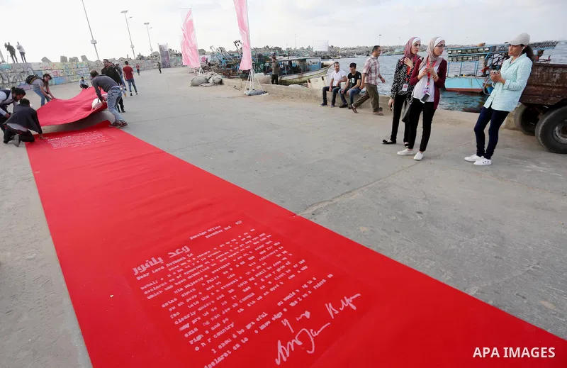 Palestinians place a red carpet during the 3rd Annual Red Carpet Festival for Human Rights Films at the Gaza seaport, on May 12, 2017. The Red Carpet Festival is held in the Gaza Strip this year for the third year in a r...