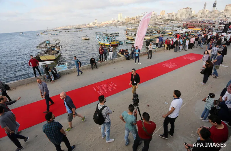 Palestinians place a red carpet during the 3rd Annual Red Carpet Festival for Human Rights Films at the Gaza seaport, on May 12, 2017. The Red Carpet Festival is held in the Gaza Strip this year for the third year in a r...
