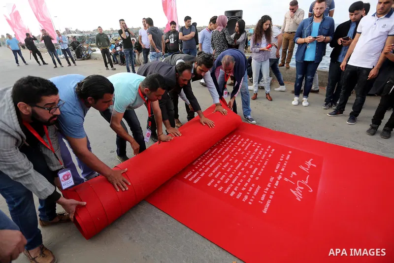 Palestinians place a red carpet during the 3rd Annual Red Carpet Festival for Human Rights Films at the Gaza seaport, on May 12, 2017. The Red Carpet Festival is held in the Gaza Strip this year for the third year in a r...