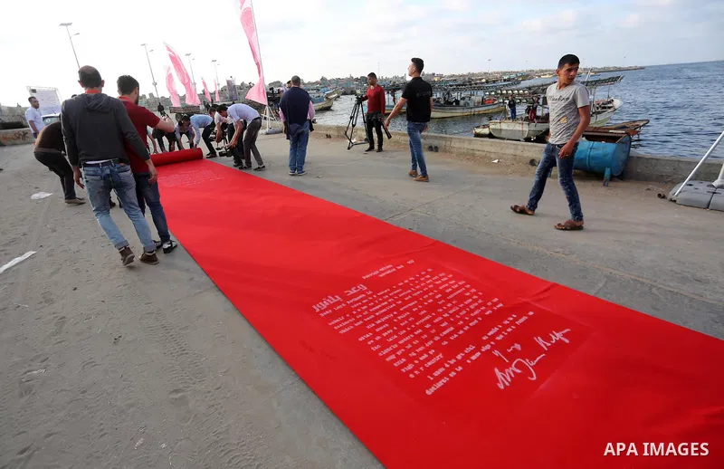 Palestinians place a red carpet during the 3rd Annual Red Carpet Festival for Human Rights Films at the Gaza seaport, on May 12, 2017. The Red Carpet Festival is held in the Gaza Strip this year for the third year in a r...
