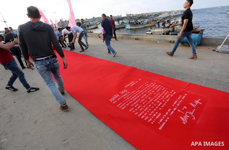 Palestinians place a red carpet during the 3rd Annual Red Carpet Festival for Human Rights Films at the Gaza seaport, on May 12, 2017. The Red Carpet Festival is held in the Gaza Strip this year for the third year in a r...