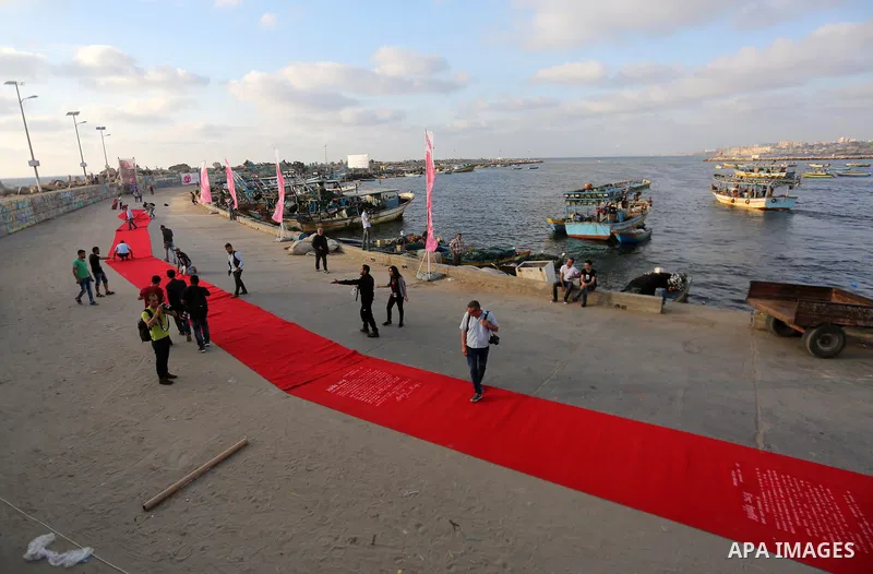 Palestinians place a red carpet during the 3rd Annual Red Carpet Festival for Human Rights Films at the Gaza seaport, on May 12, 2017. The Red Carpet Festival is held in the Gaza Strip this year for the third year in a r...
