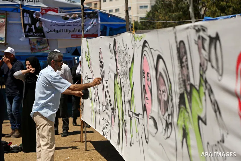 Palestinian artists paint a mural in solidarity with Palestinian prisoners on hunger strike in Israeli jails, and to commemorate the 68th anniversary of the "Nakba" or "catastrophe" in Arabic in reference to the establis...