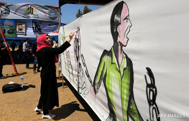 A Palestinian artist paints a mural in solidarity with Palestinian prisoners on hunger strike in Israeli jails, and to commemorate the 68th anniversary of the "Nakba" or "catastrophe" in Arabic in reference to the establ...