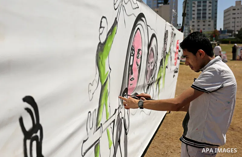 A Palestinian artist paints a mural in solidarity with Palestinian prisoners on hunger strike in Israeli jails, and to commemorate the 68th anniversary of the "Nakba" or "catastrophe" in Arabic in reference to the establ...