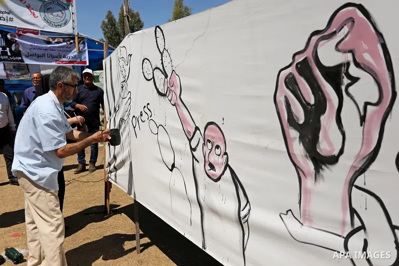 A Palestinian artist paints a mural in solidarity with Palestinian prisoners on hunger strike in Israeli jails, and to commemorate the 68th anniversary of the "Nakba" or "catastrophe" in Arabic in reference to the establ...