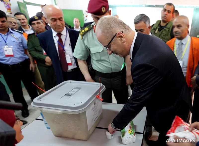 Palestinian Prime Minister Rami Hamdallah has his finger stained with ink as he casts his ballot at a polling station during municipal elections in the northern West Bank town of Anabta, near Tulkarm May 13, 2017. Photo...