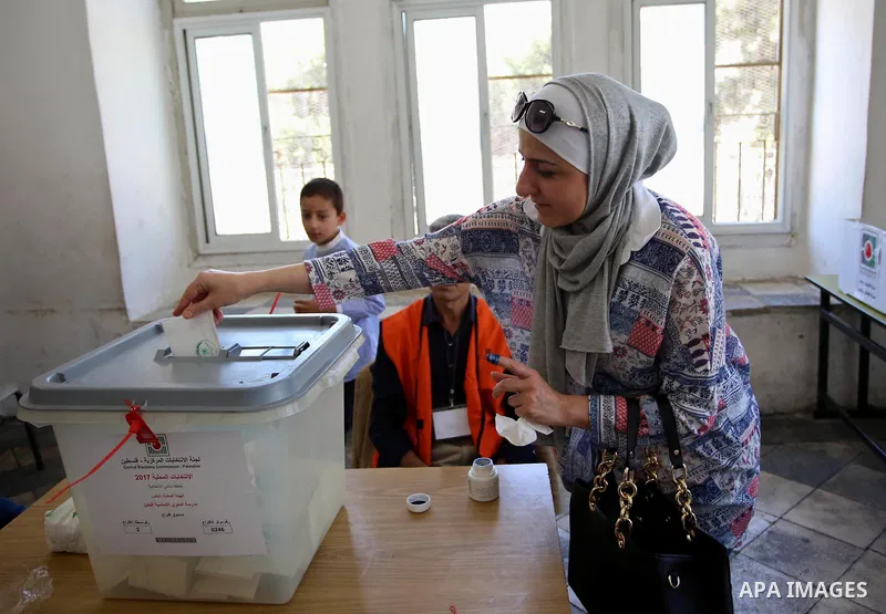 A Palestinian woman casts her ballot at a polling station during municipal elections in the West Bank of Nablus on May 13, 2017. Photo by Ayman Ameen