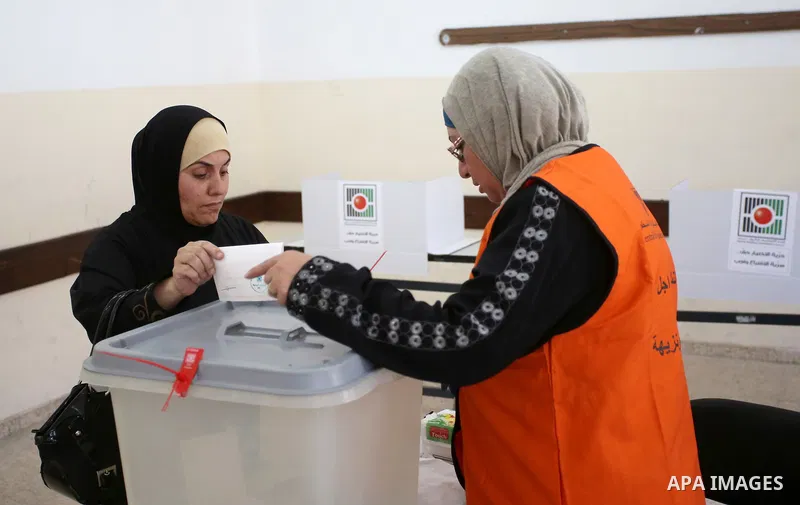A Palestinian woman casts her ballot at a polling station during municipal elections in the West Bank of Nablus on May 13, 2017. Photo by Ayman Ameen