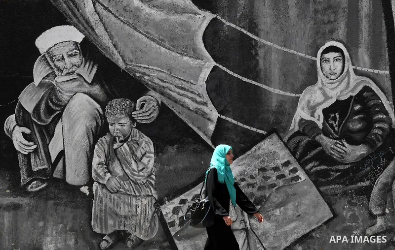 A Palestinian woman walks past a mural on the occasion of the 69th anniversary of the "Nakba" or "catastrophe" in Arabic in reference to the establishment in 1948 of the state of Israel, in Gaza city on May 15, 2017. Nak...