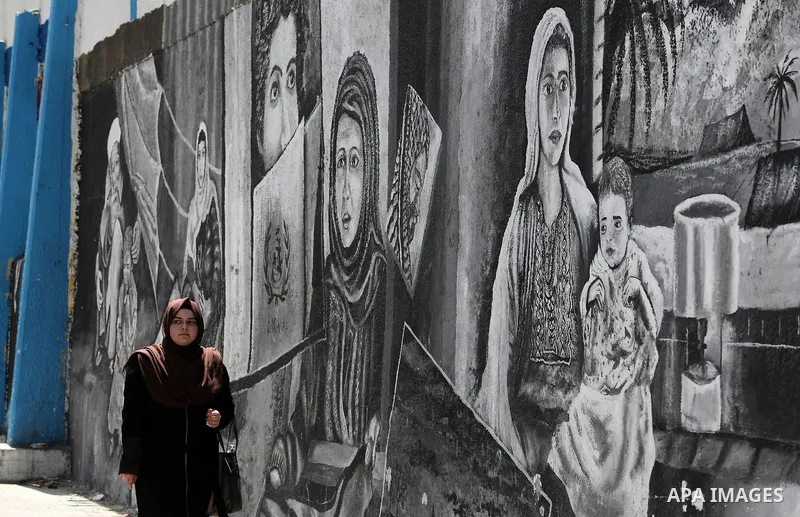 A Palestinian woman walks past a mural on the occasion of the 69th anniversary of the "Nakba" or "catastrophe" in Arabic in reference to the establishment in 1948 of the state of Israel, in Gaza city on May 15, 2017. Nak...