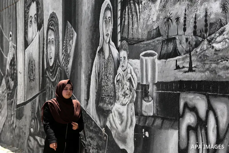 A Palestinian woman walks past a mural on the occasion of the 69th anniversary of the "Nakba" or "catastrophe" in Arabic in reference to the establishment in 1948 of the state of Israel, in Gaza city on May 15, 2017. Nak...