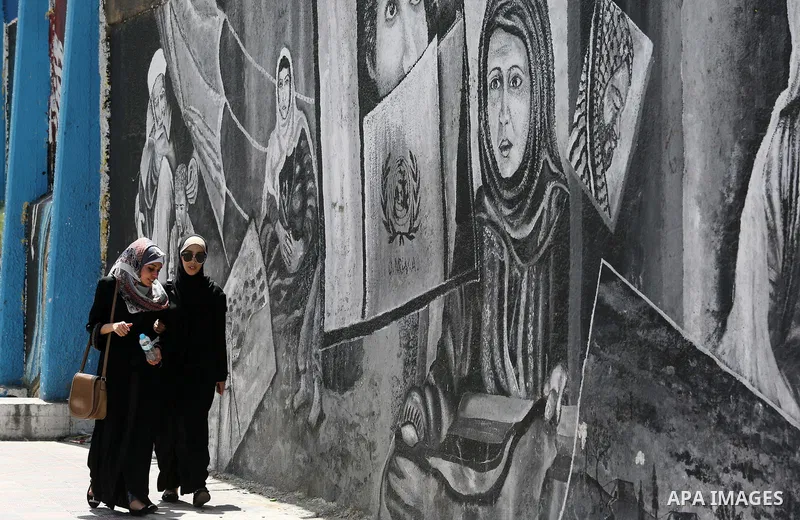 Palestinian women walk past a mural on the occasion of the 69th anniversary of the "Nakba" or "catastrophe" in Arabic in reference to the establishment in 1948 of the state of Israel, in Gaza city on May 15, 2017. Nakba"...