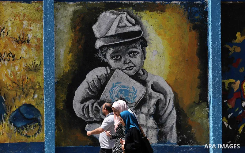 Palestinians walk past a mural on the occasion of the 69th anniversary of the "Nakba" or "catastrophe" in Arabic in reference to the establishment in 1948 of the state of Israel, in Gaza city on May 15, 2017. Nakba" mean...