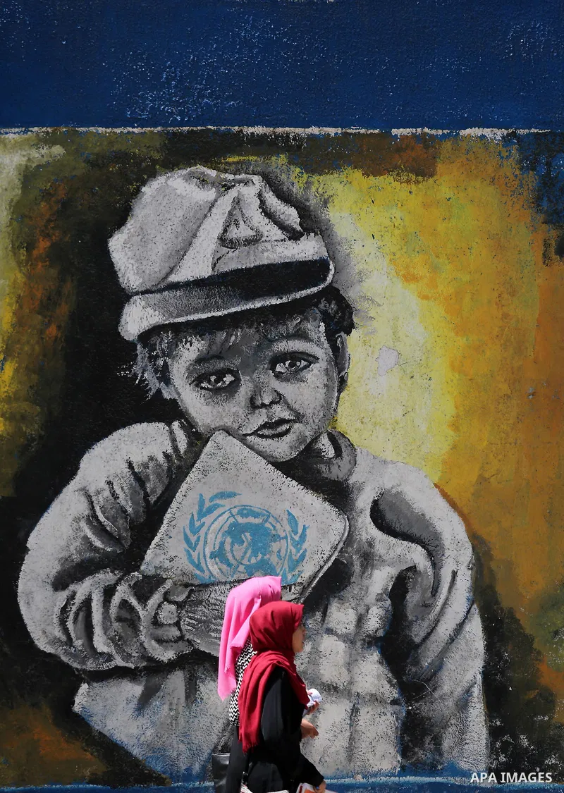 Palestinian women walk past a mural on the occasion of the 69th anniversary of the "Nakba" or "catastrophe" in Arabic in reference to the establishment in 1948 of the state of Israel, in Gaza city on May 15, 2017. Nakba"...