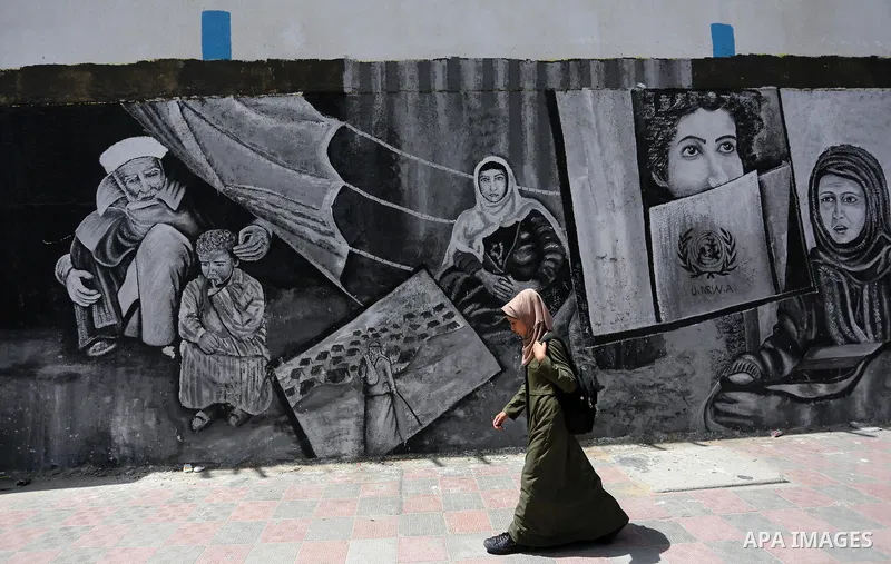 A Palestinian woman walks past a mural on the occasion of the 69th anniversary of the "Nakba" or "catastrophe" in Arabic in reference to the establishment in 1948 of the state of Israel, in Gaza city on May 15, 2017. Nak...