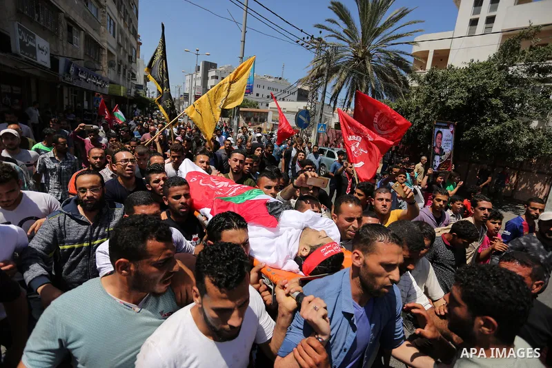 Palestinian mourners carry the body of Mohammed Majed Bakr, a 25-year-old fisherman who died from his injuries after an Israeli patrol vessel fired at a fishing boat, during his funeral in Gaza City on May 16, 2017. The...