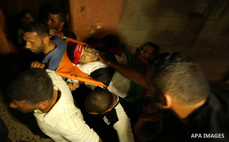 Palestinian mourners carry the body of Mohammed Majed Bakr, a 25-year-old fisherman who died from his injuries after an Israeli patrol vessel fired at a fishing boat, during his funeral in Gaza City on May 16, 2017. The...